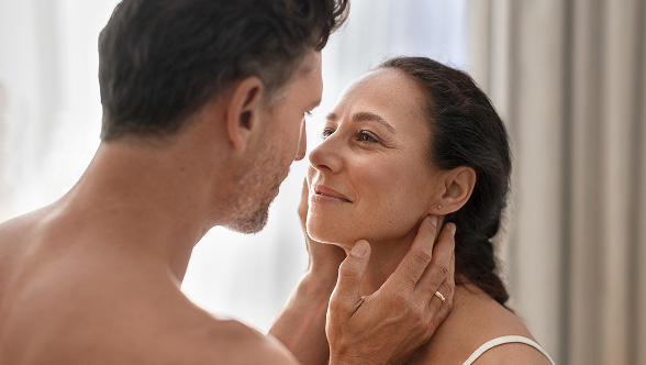 Duas pessoas em ambiente interno interagem de frente, ilustrando o conceito de TICI, implante coclear invisível e totalmente implantável, sem componentes externos visíveis.